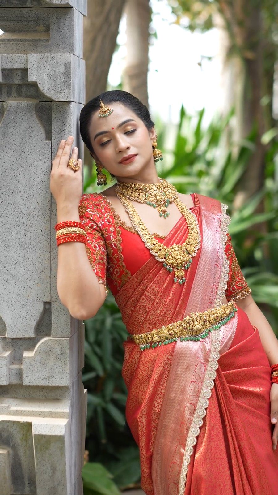 Red and gold silk saree worn with a matching elbow-sleeve blouse