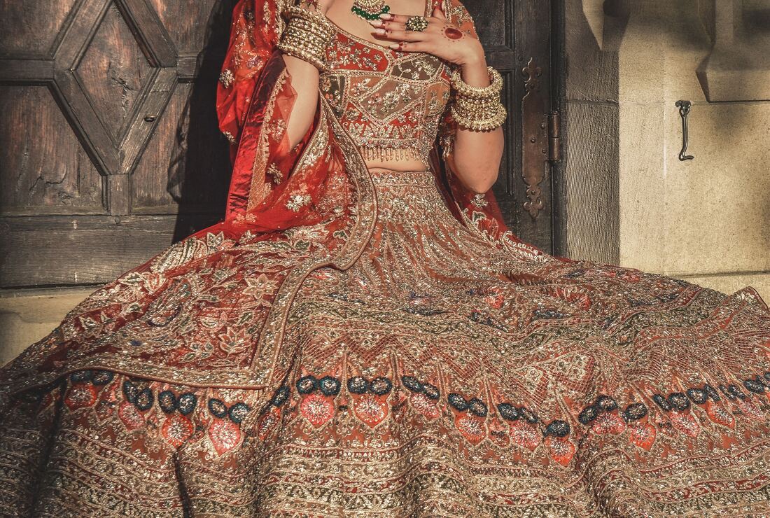 Bride in a heavily embroidered bridal lehenga with a full skirt spread